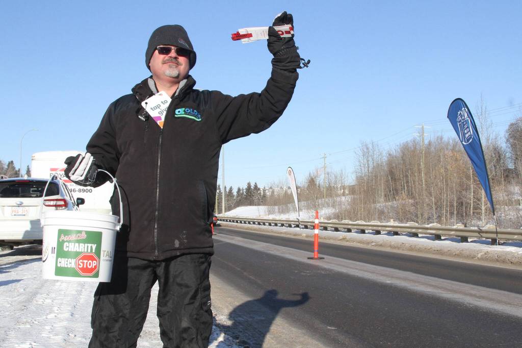 Red Deer Food Bank executive director Mitch Thomson collects donations at a previous Charity Checkstop event. These fundraisers are no longer allowed on public roads, but there will be a Charity Drive-Thru event on Dec. 13 at 6290 67A St. (Advocate file photo)